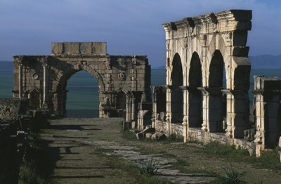 Portico on the Decumanus Maximus and triumphal arch of Caracalla by Roman